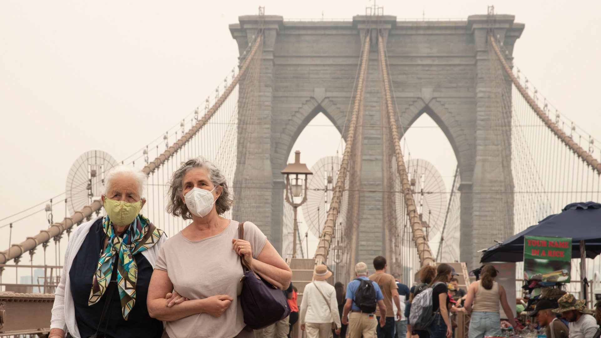 Varias personas caminan por el puente de Brooklyn con tapabocas para cuidar su salud (EFE)