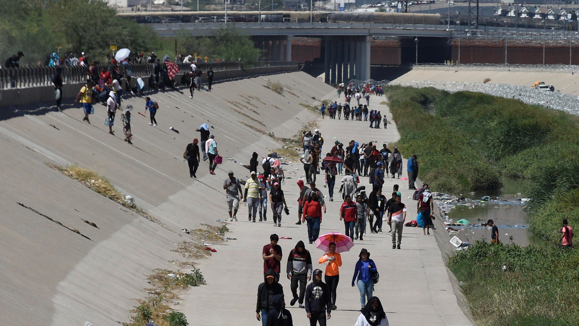 MEX5745. CIUDAD JUÁREZ (MÉXICO), 19/09/2023.- Migrantes caminan hou, a un costado de la frontera con Estados Unidos después de que la Guardia Nacional de Estados Unidos los retirara de un campamento, en Ciudad Juárez, Chihuahua (México). - EFE