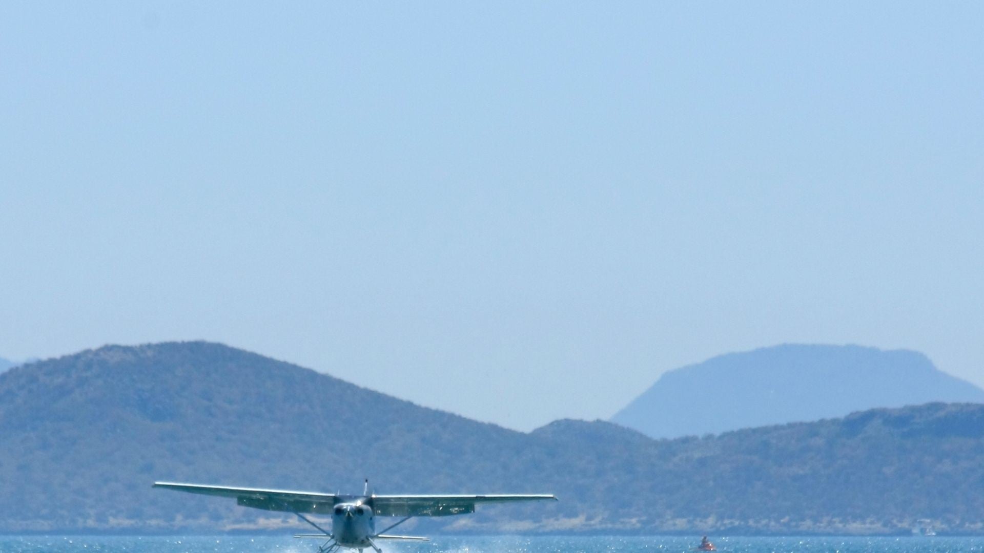 Avión vuela cerca al mar (foto de referencia - Canva)