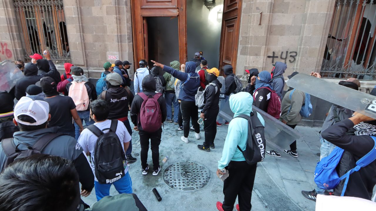 Manifestantes encapuchados usan un vehículo para vandalizar una de las puertas del Palacio Nacional de México - Foto: EFE