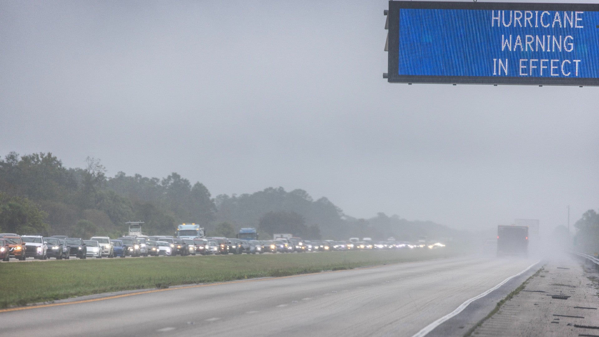 Vehículos pasan bajo un cartel de advertencia de tormenta tropical vigente debido al huracán Milton en Naples, Florida - Foto: EFE Vehículos pasan bajo un cartel de advertencia de tormenta tropical vigente debido al huracán Milton en Naples, Florida - Foto: EFE