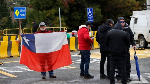 Un hombre sostiene bandera Chile en acceso Los Maitenes, en la mina El Teniente - Foto EFE