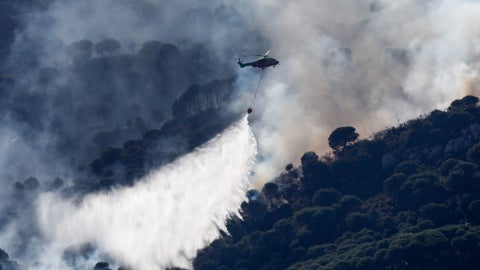 Un helicóptero en labores de extinción de un incendio declarado en el paraje del monte La Peña, en la localidad gaditana de Tarifa (España) - Foto: EFE