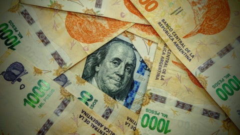 Dólar y peso argentino (Canva)