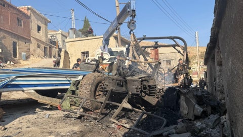 Una grúa retira un Humvee israelí quemado de una calle en la aldea de Beit Jin, en el sur de Siria, el 28 de noviembre de 2025. (AFP)