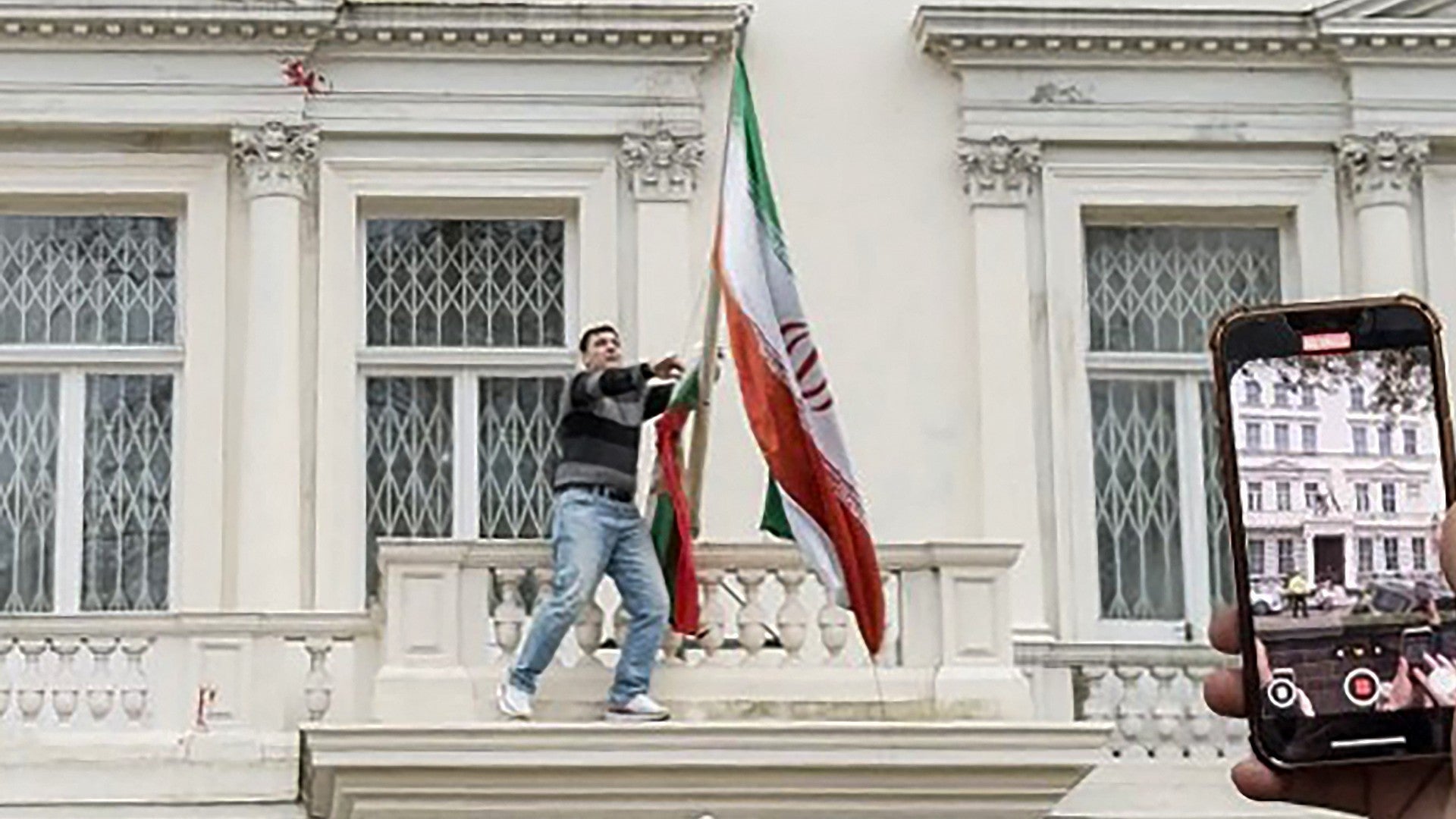Manifestante bajó la bandera del régimen iraní en la embajada en Londres / FOTO: AFP