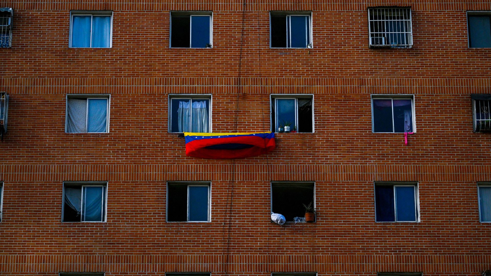 Bandera venezolana cuelga en ventanas de complejo de viviendas de Caracas - Foto AFP