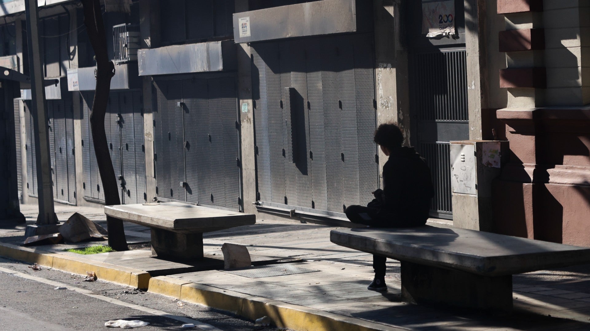Un hombre espera afuera de tiendas sin abrir durante un apagón en Caracas, Venezuela - Foto de referencia: EFE