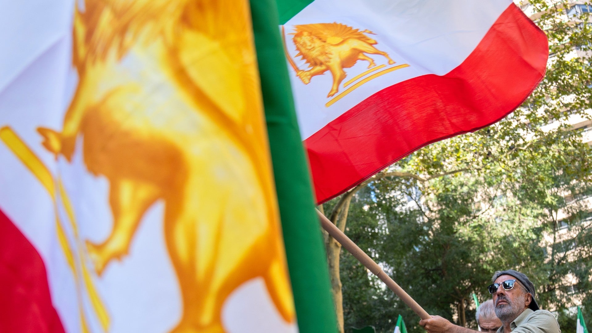 Personas ondean la bandera de Irán con un felino (específicamente un león) y un sol en el centro, como una señal de protesta, resistencia y oposición al actual régimen de la República Islámica - Foto: EFE