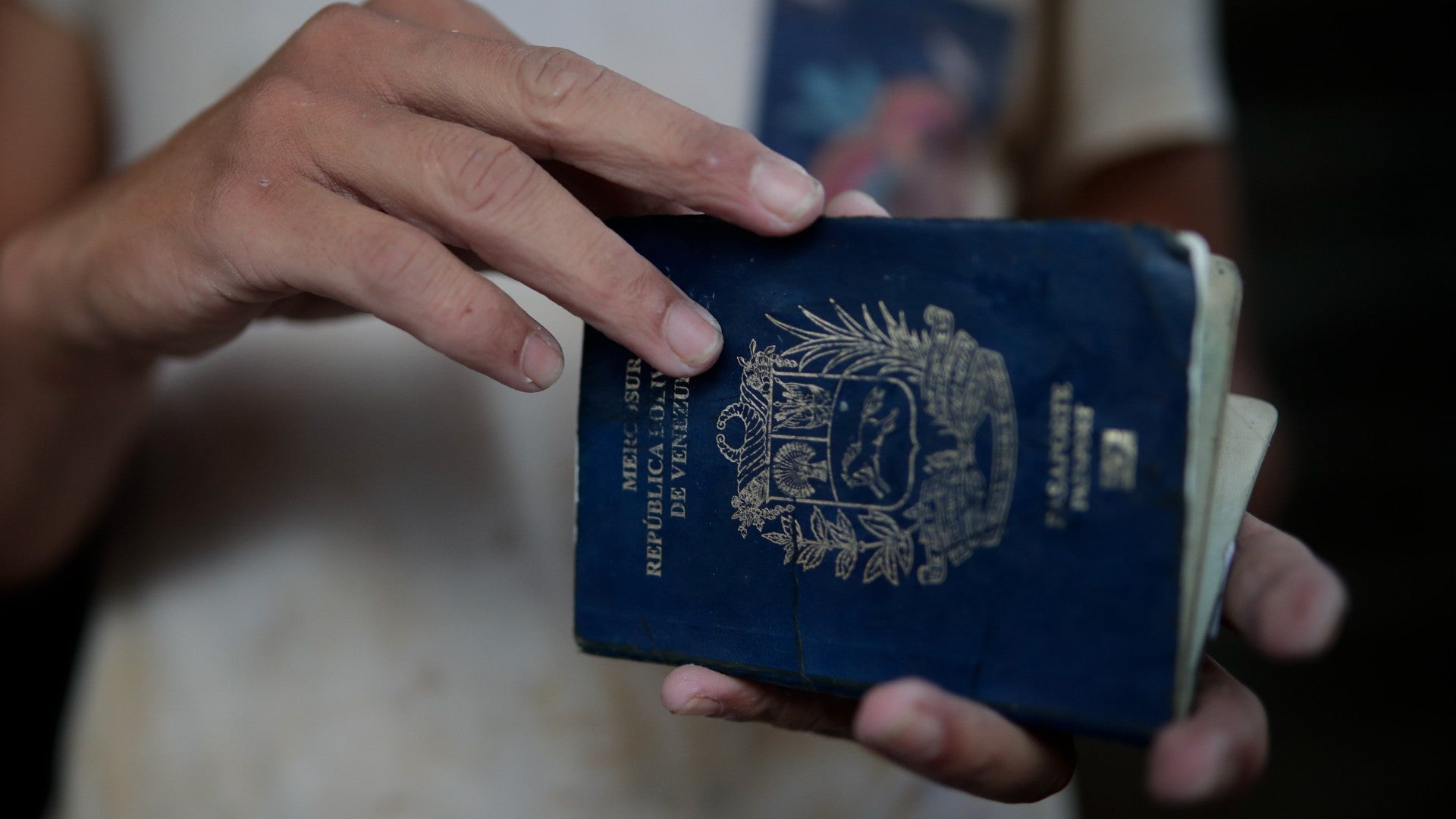 Migrante venezolano revisa su pasaporte - Foto de referencia: EFE