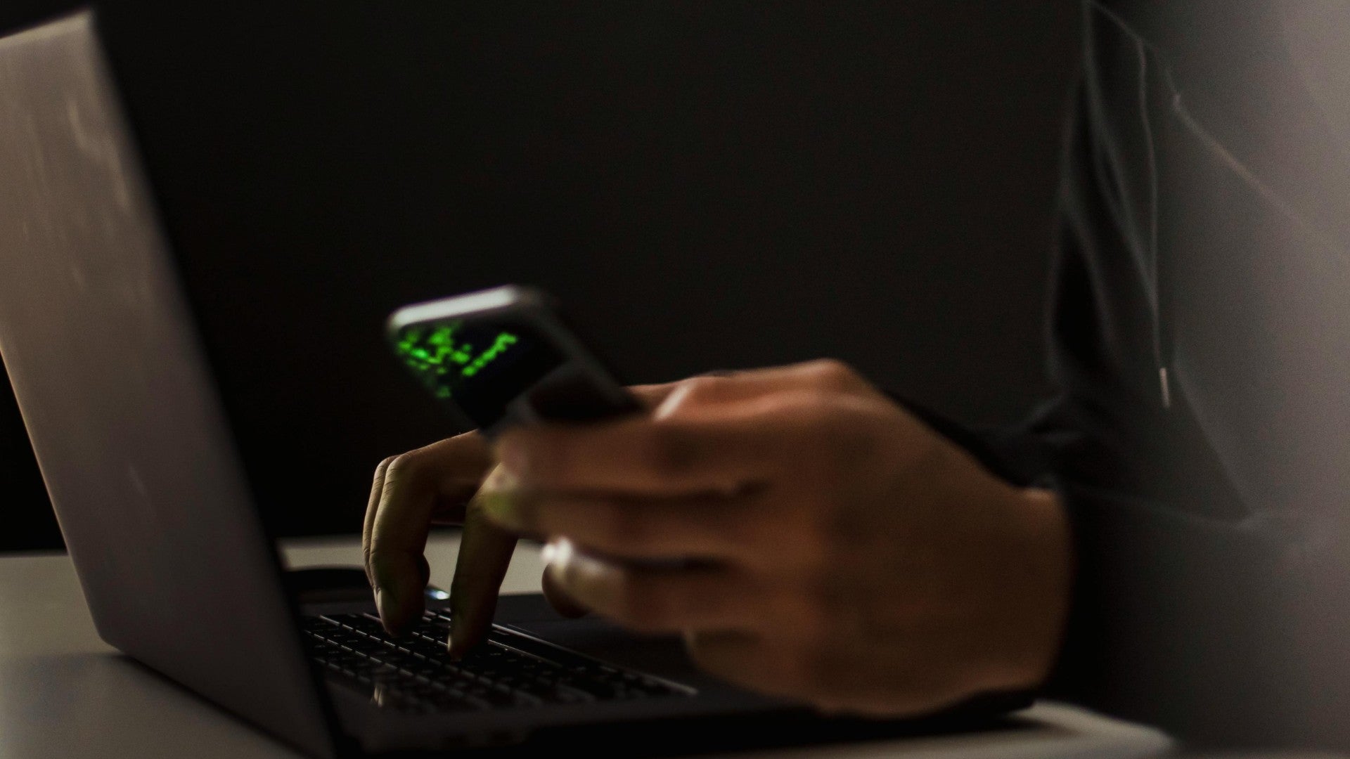 Una persona manipula una computadora y un celular - Foto de referencia - Pexels