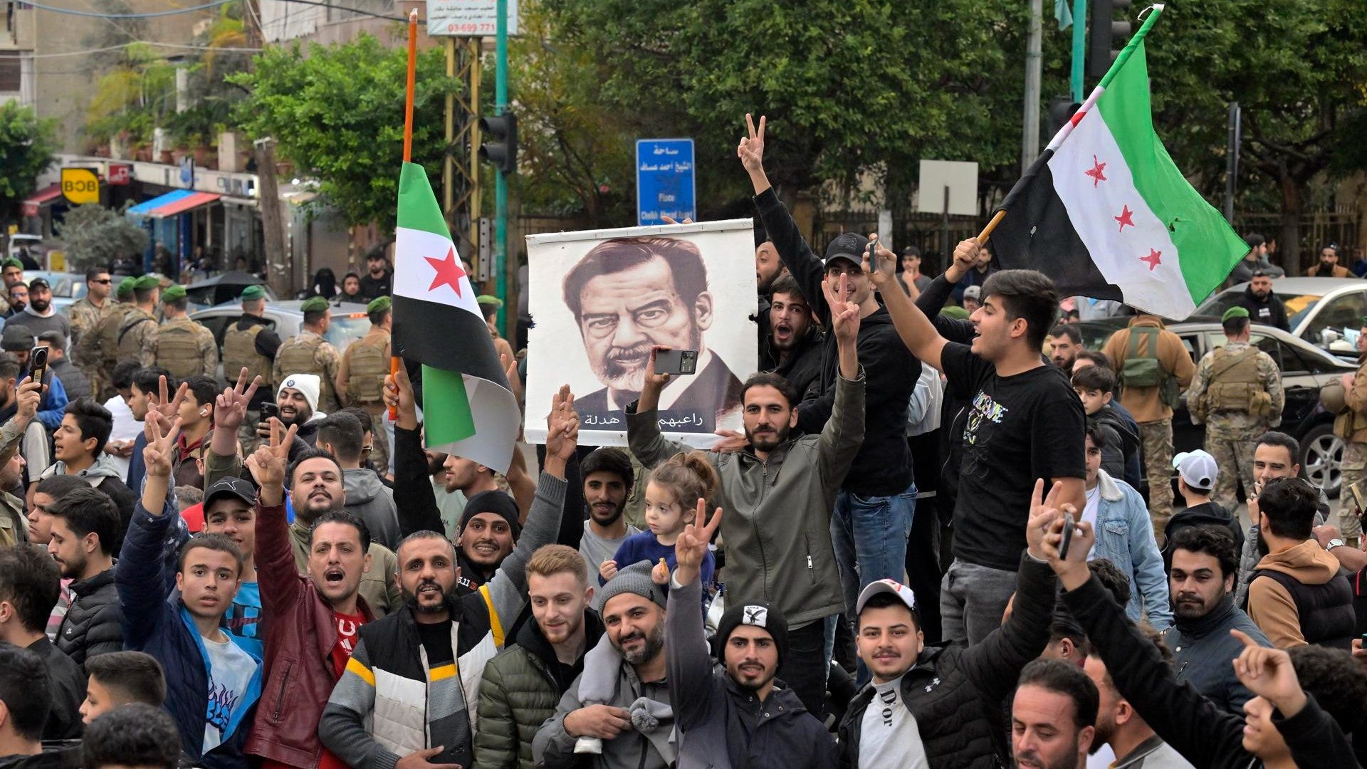 Manifestantes con cuadro de Saddam Hussein. (EFE)
