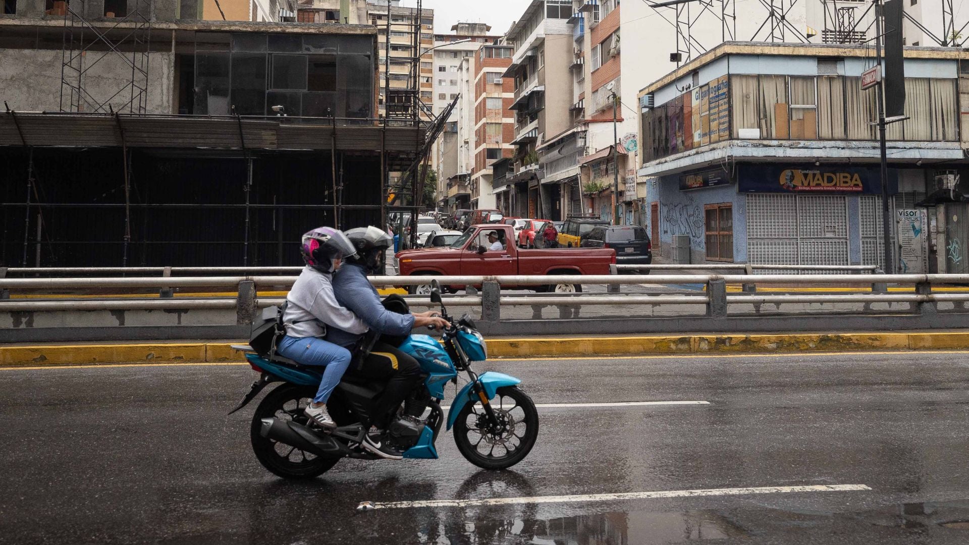 Personas en motocicleta pasan por una vía en Chacao, Caracas (Venezuela) - Foto de referencia: EFE