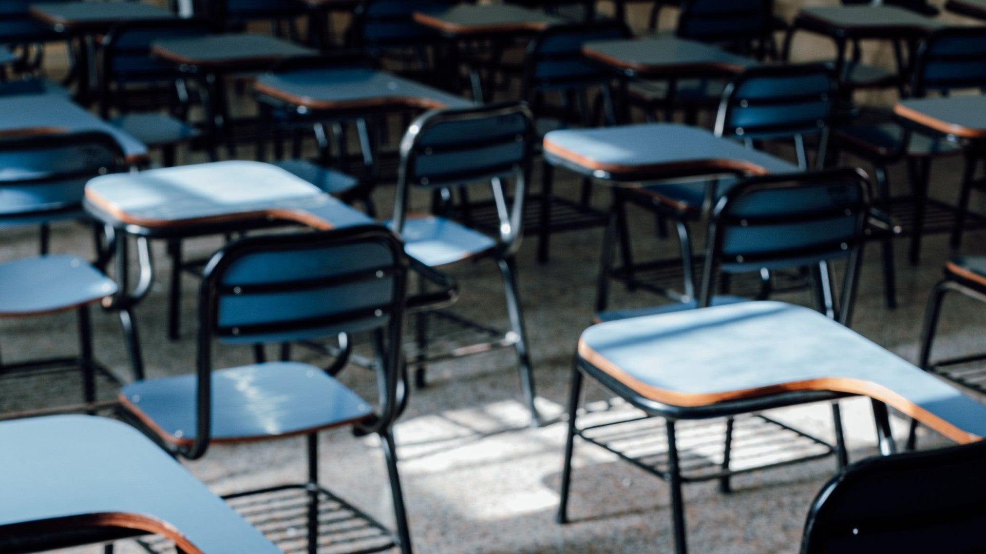 Un aula vacía llena de filas ordenadas de pupitres - Foto de referencia: Pexels