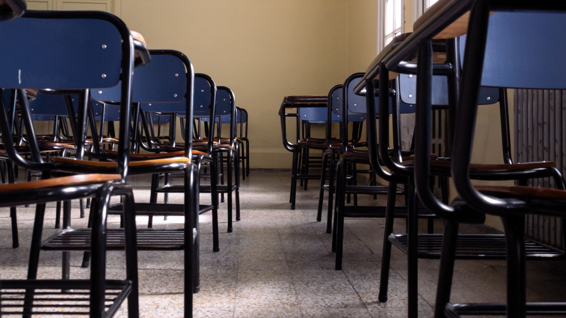 Un aula vacía llena de filas ordenadas de pupitres - Foto de referencia: Pexels