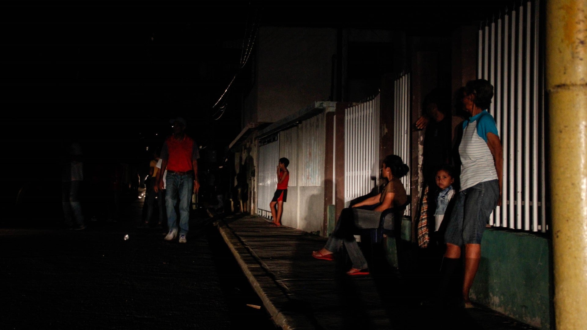 Grupo de personas permanece en el frente de sus casas a oscuras por el corte del servicio eléctrico en Maracaibo (Venezuela) - Foto de referencia: EFE