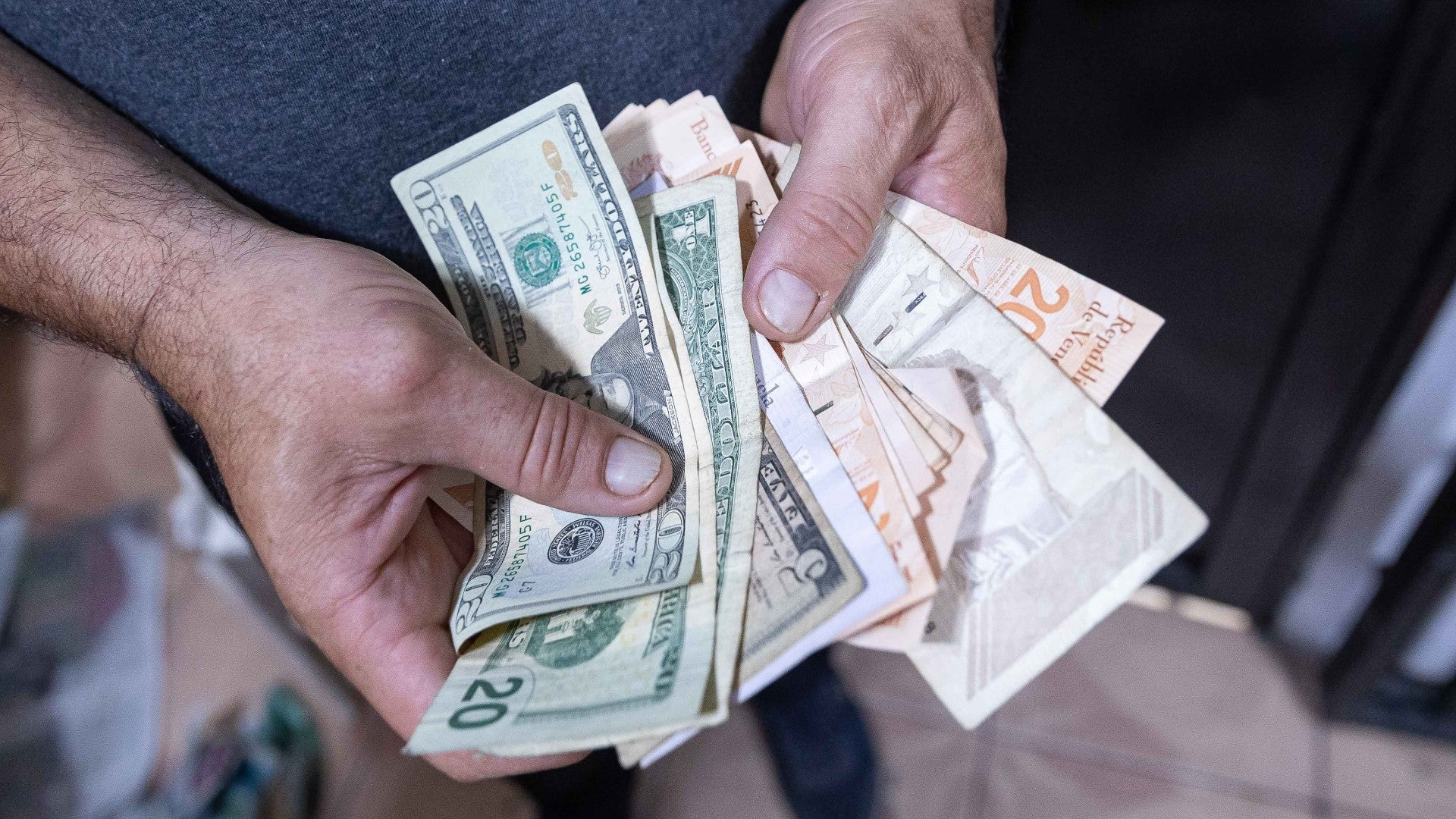 Un hombre cuenta billetes en Caracas (Venezuela) - EFE