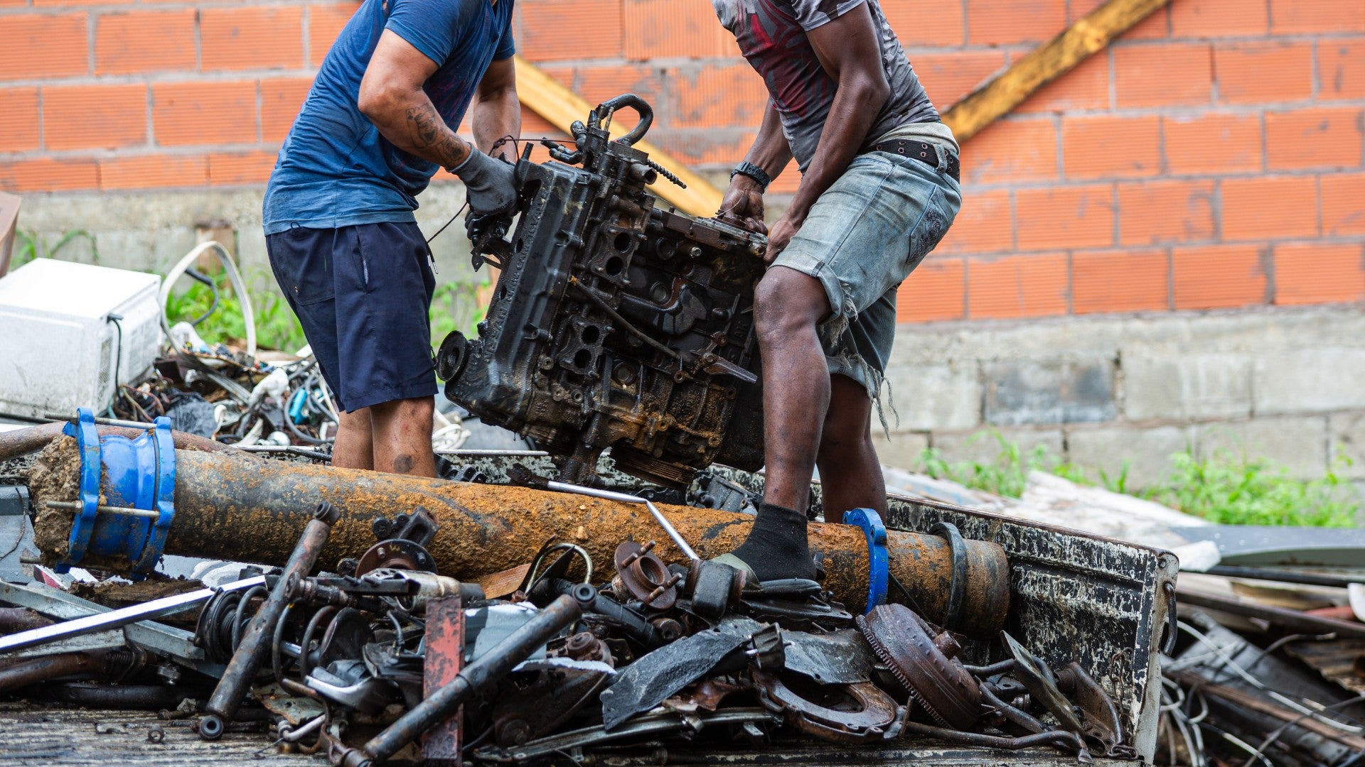 Fotografía de trabajadores descargando chatarra de un camión en un centro de chatarras en Claxton Bay (Trinidad y Tobago) - EFE