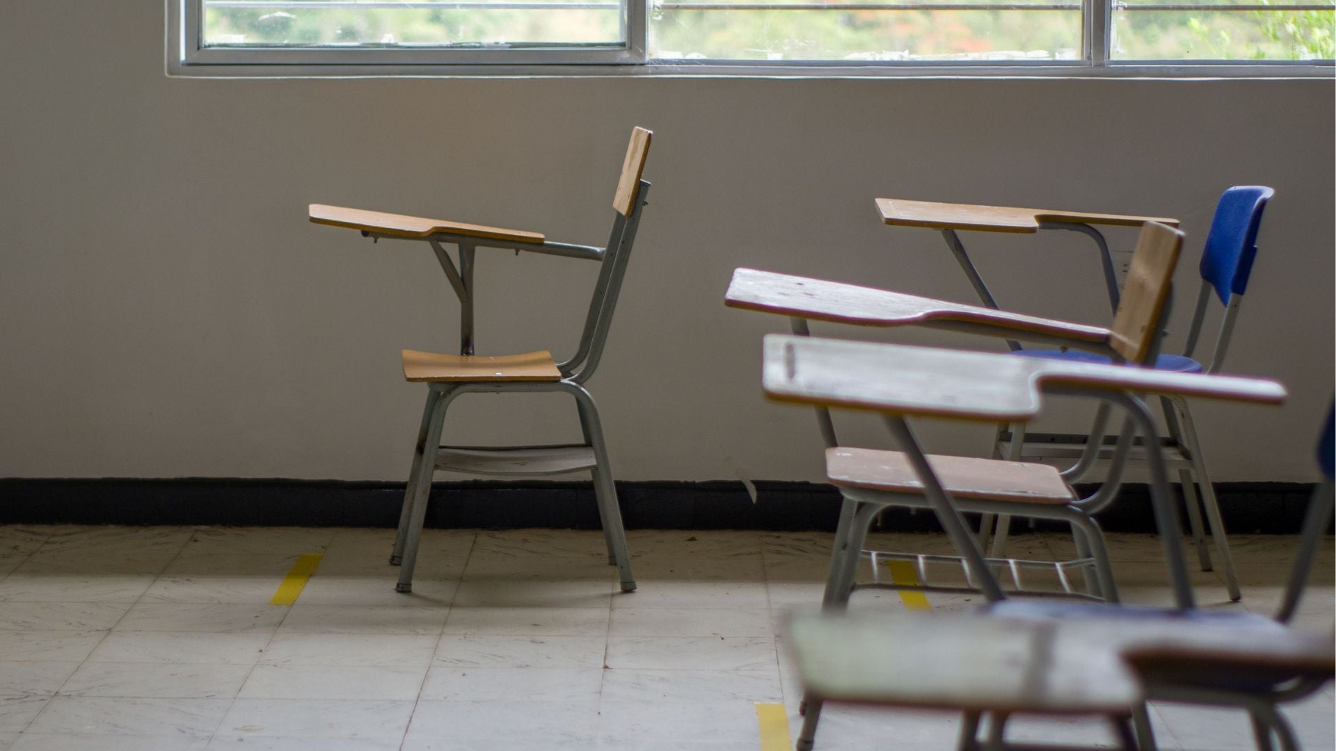 Aula vacía con pupitres junto a una ventana - Foto de referencia: Pexels