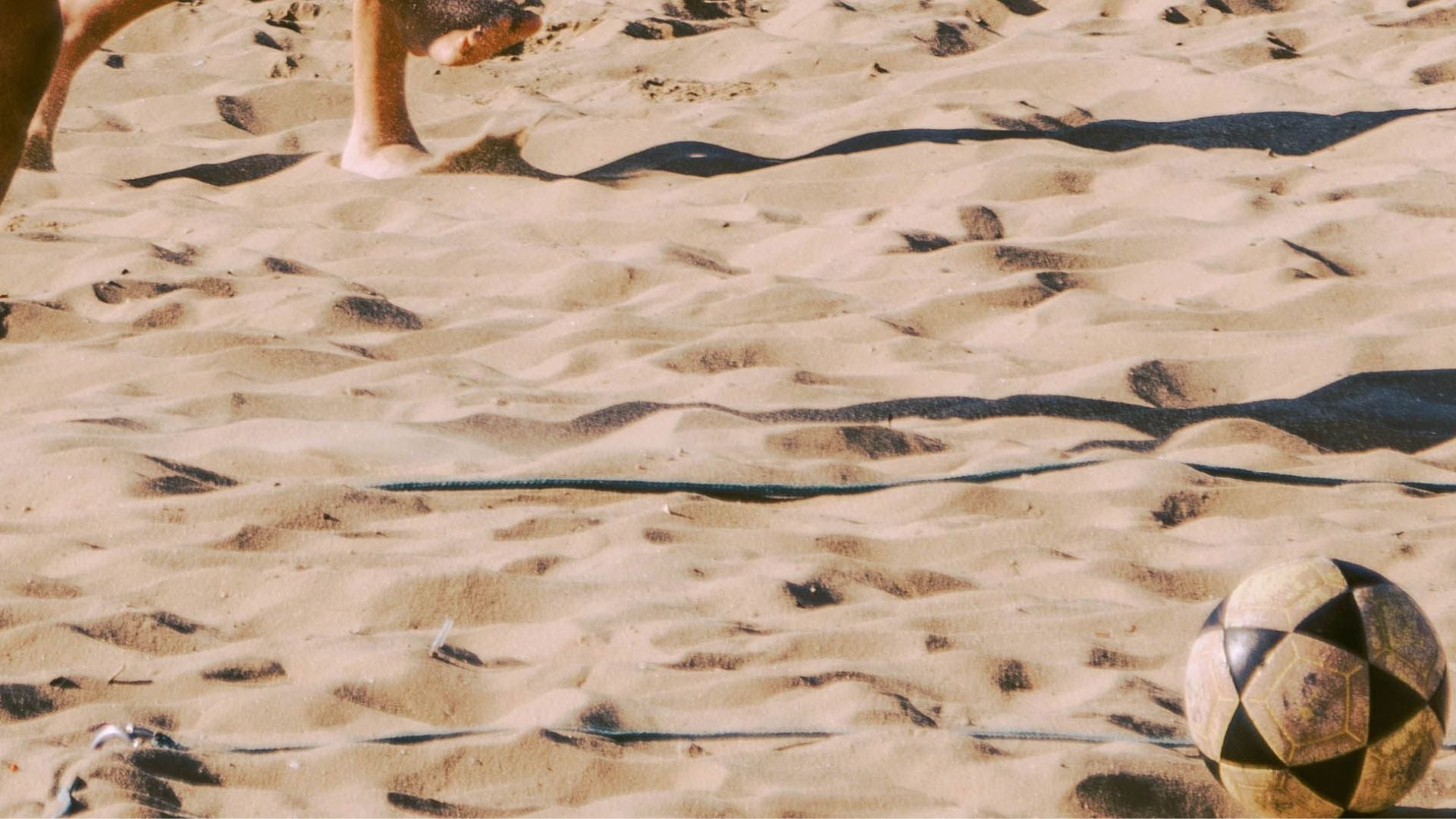 Jóvenes jugando al fútbol de playa en una costa soleada - Foto de referencia: Pexels