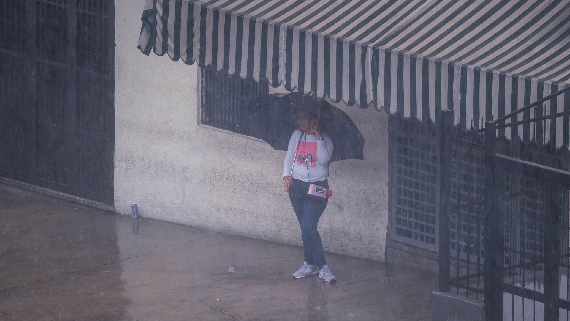 Una mujer espera que pase un fuerte aguacero en Caracas (Venezuela) - Foto de referencia: EFE