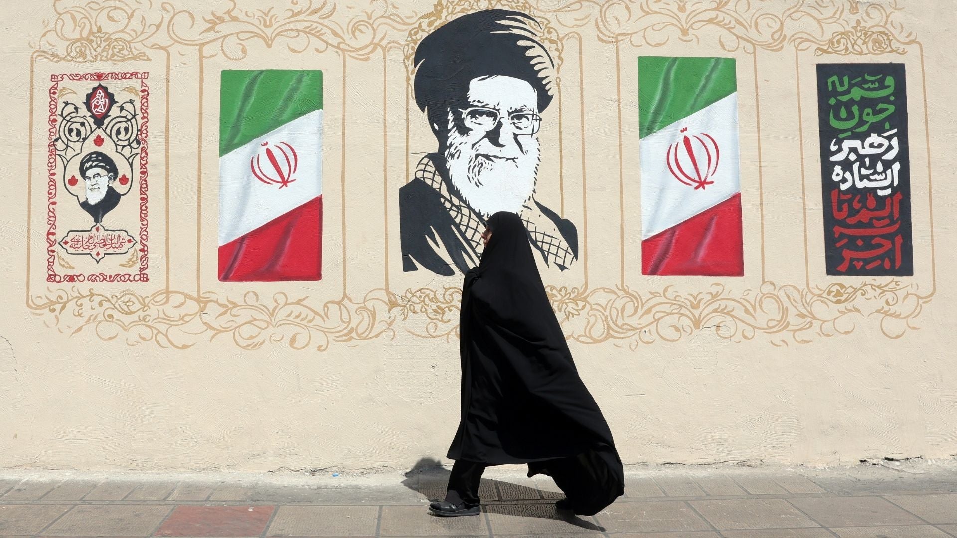 Una mujer camina al frente de propaganda del régimen de Irán-Foto: EFE