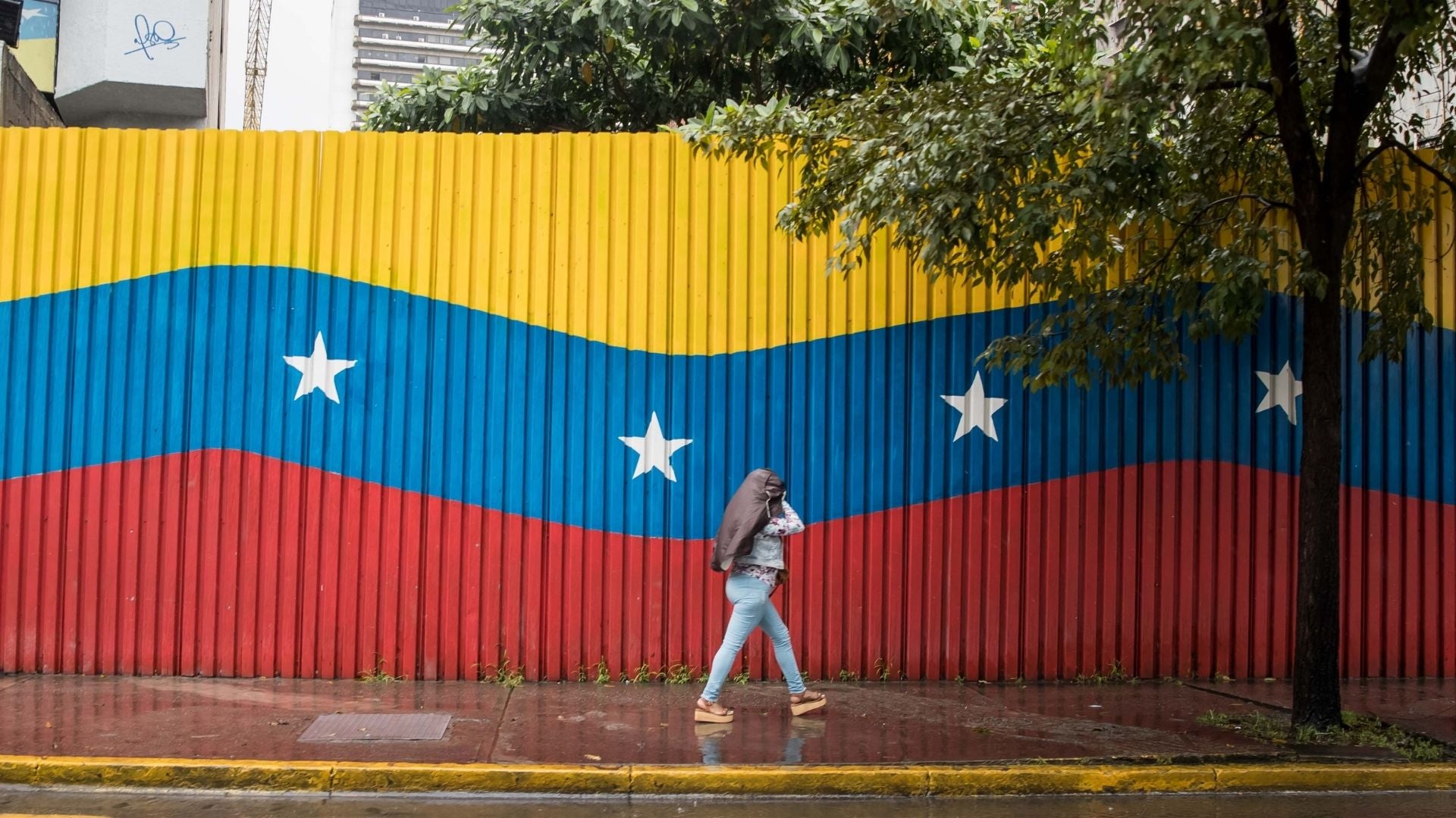 Una mujer camina bajo la lluvia, en Caracas (Venezuela) - Foto de referencia: EFE