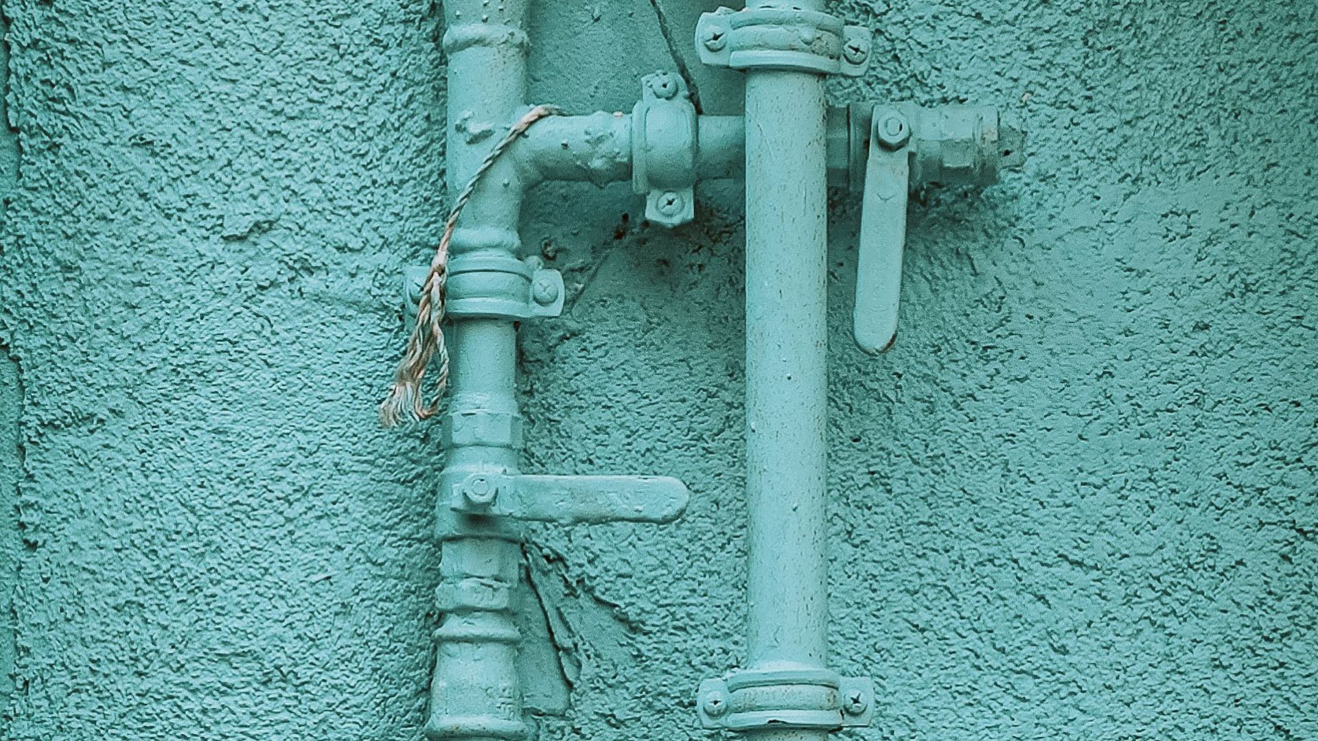 Medidor de gas azul con tuberías en la pared exterior de un edificio - Foto de referencia: Pexels
