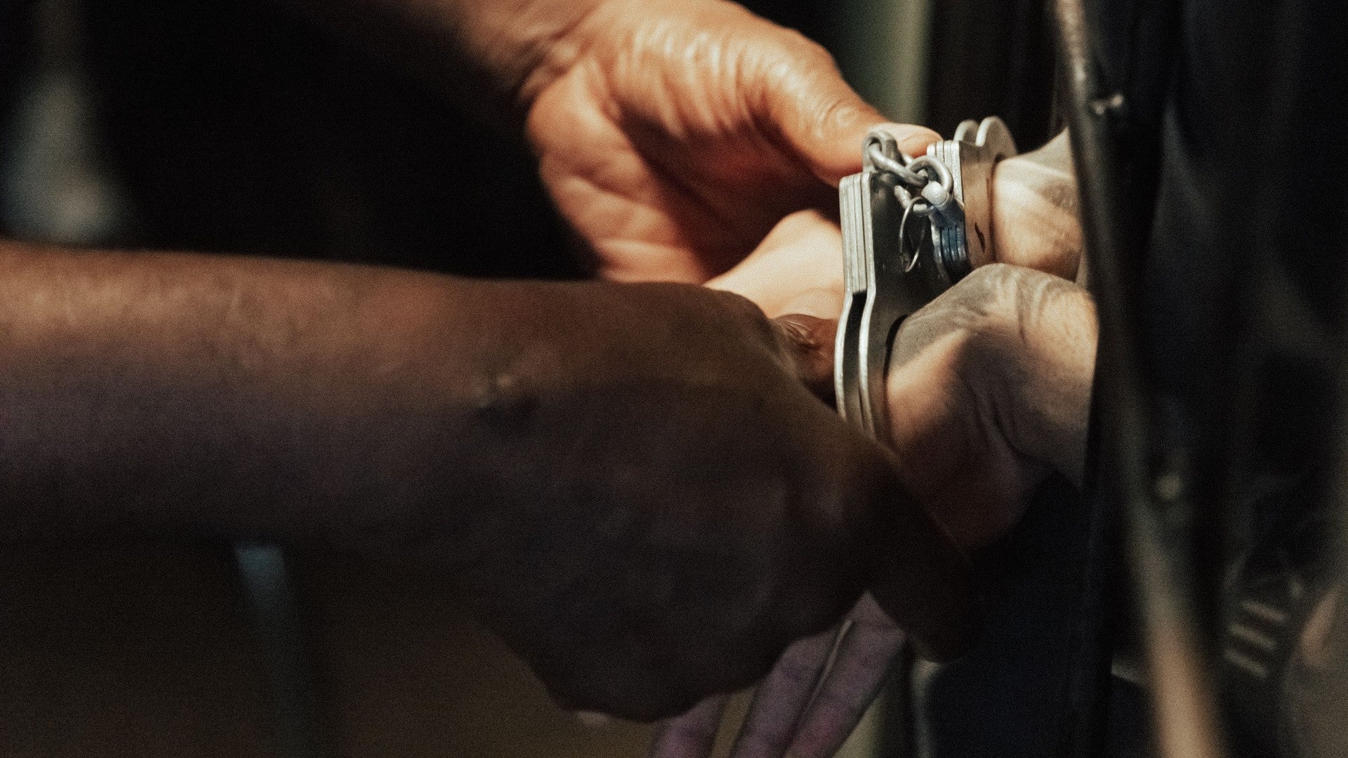 Manos esposadas a las barras de la celda - Foto de referencia: Pexels