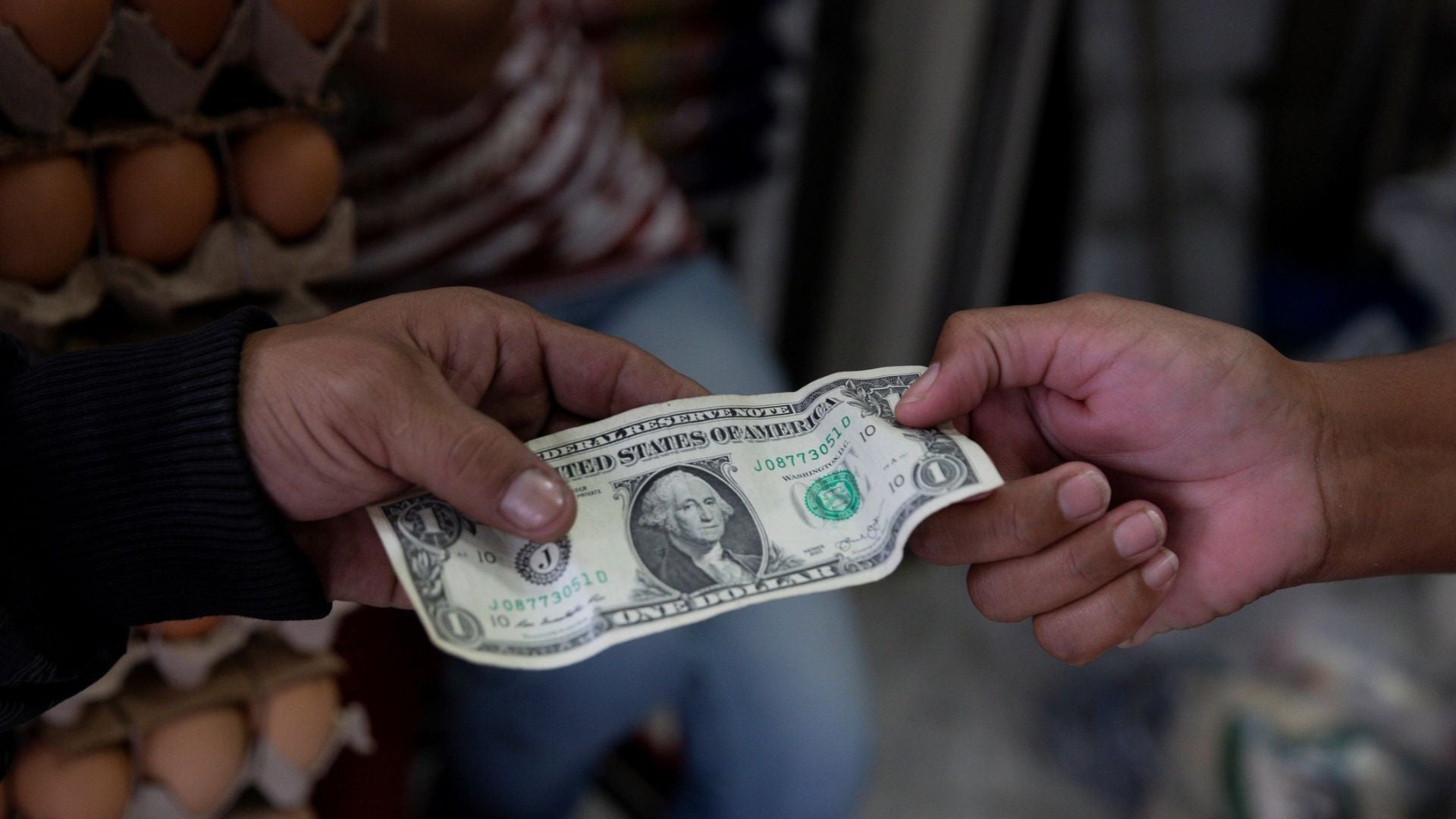 Un hombre realiza un pago con dólares en Caracas (Venezuela) - Foto de referencia: EFE