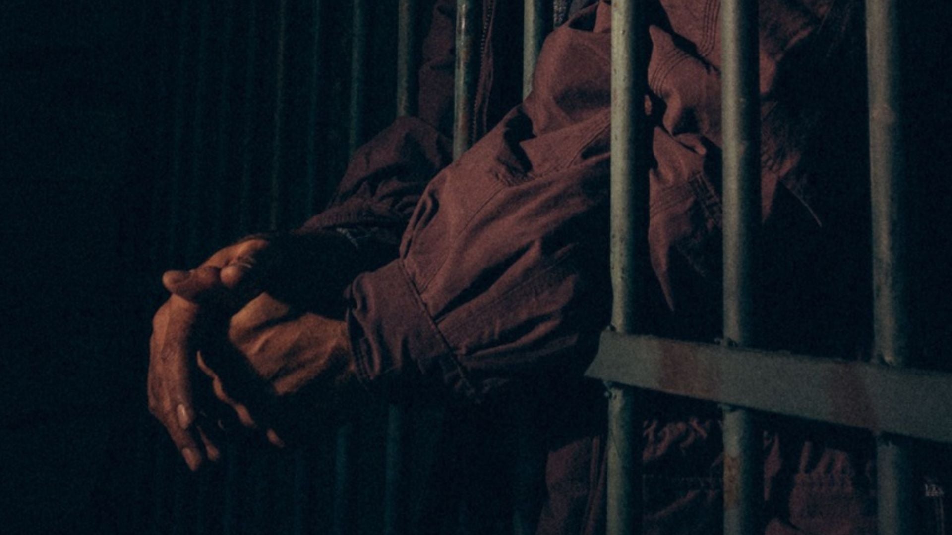 Un hombre detrás de las rejas en una oscura celda de prisión - Foto de referencia: Pexels
