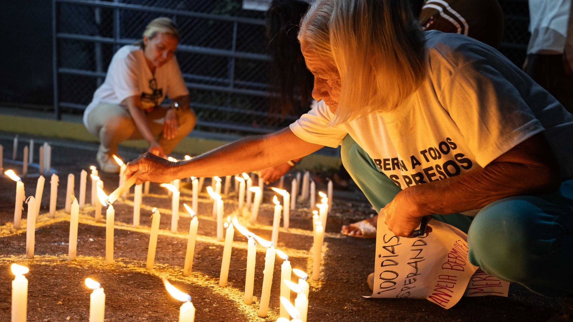 Personas encienden velas durante una vigilia afuera de la cárcel El Rodeo I (Venezuela) - Foto de referencia: EFE