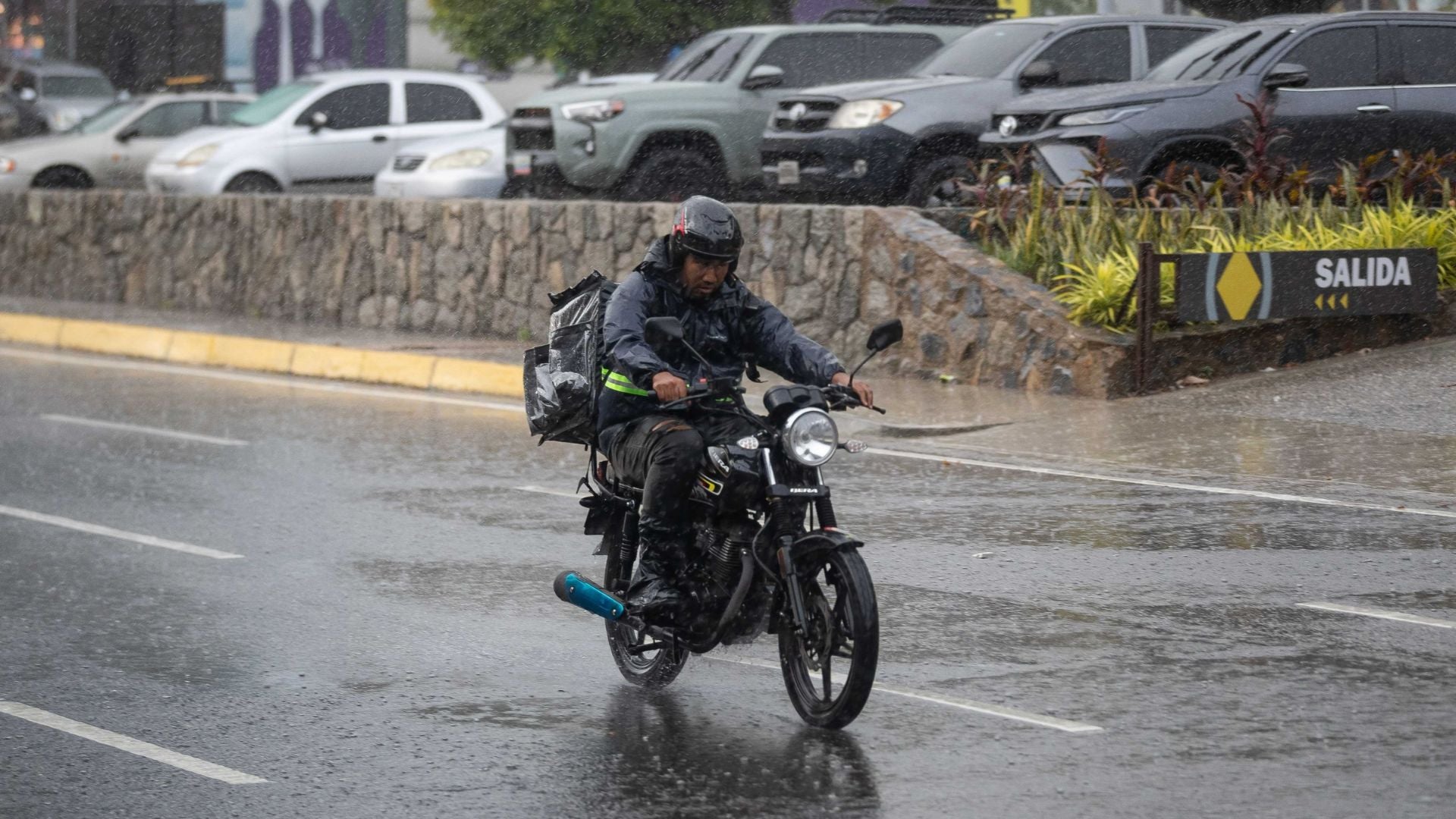 Un hombre se desplaza en motocicleta bajo la lluvia en Caracas (Venezuela) - Foto de referencia: EFE