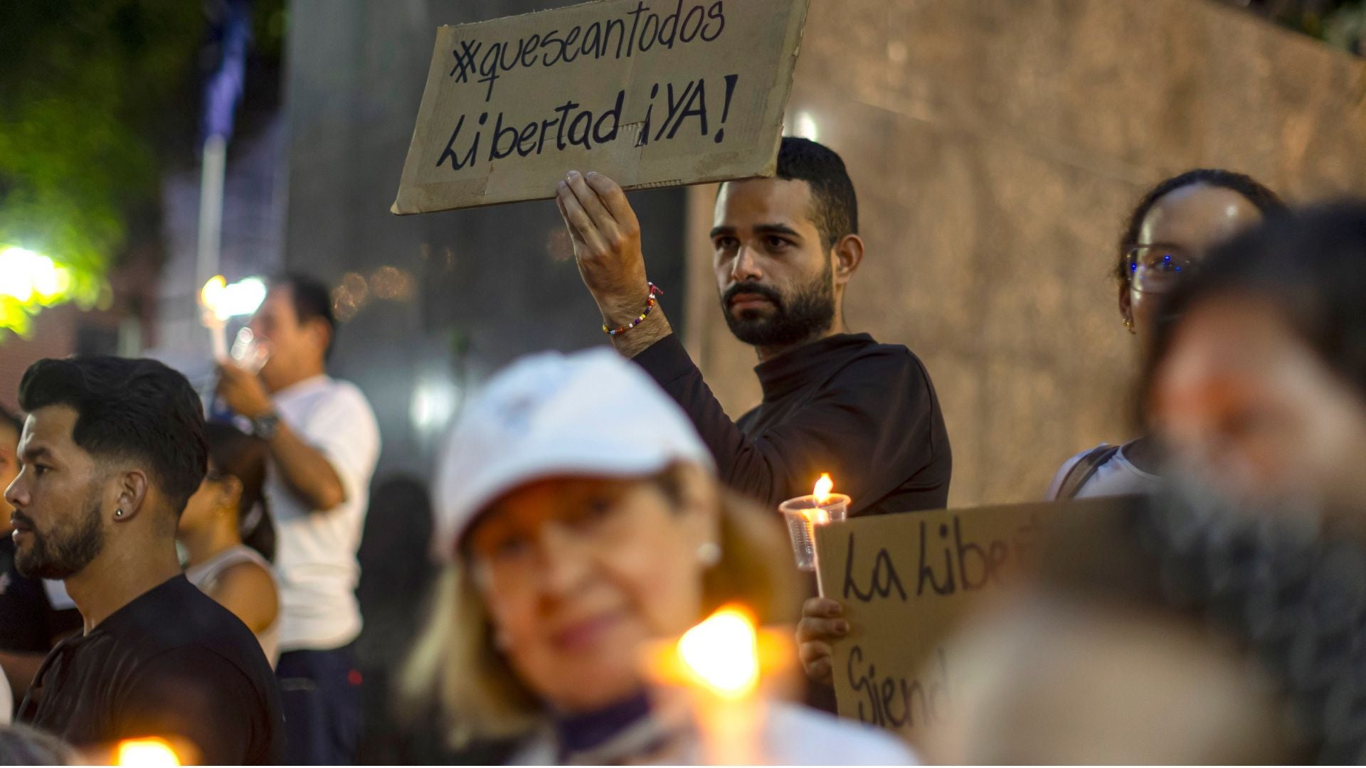 Un hombre sostiene un cartel en una vigilia para orar por la liberación de los presos políticos en Venezuela. - Foto: EFE