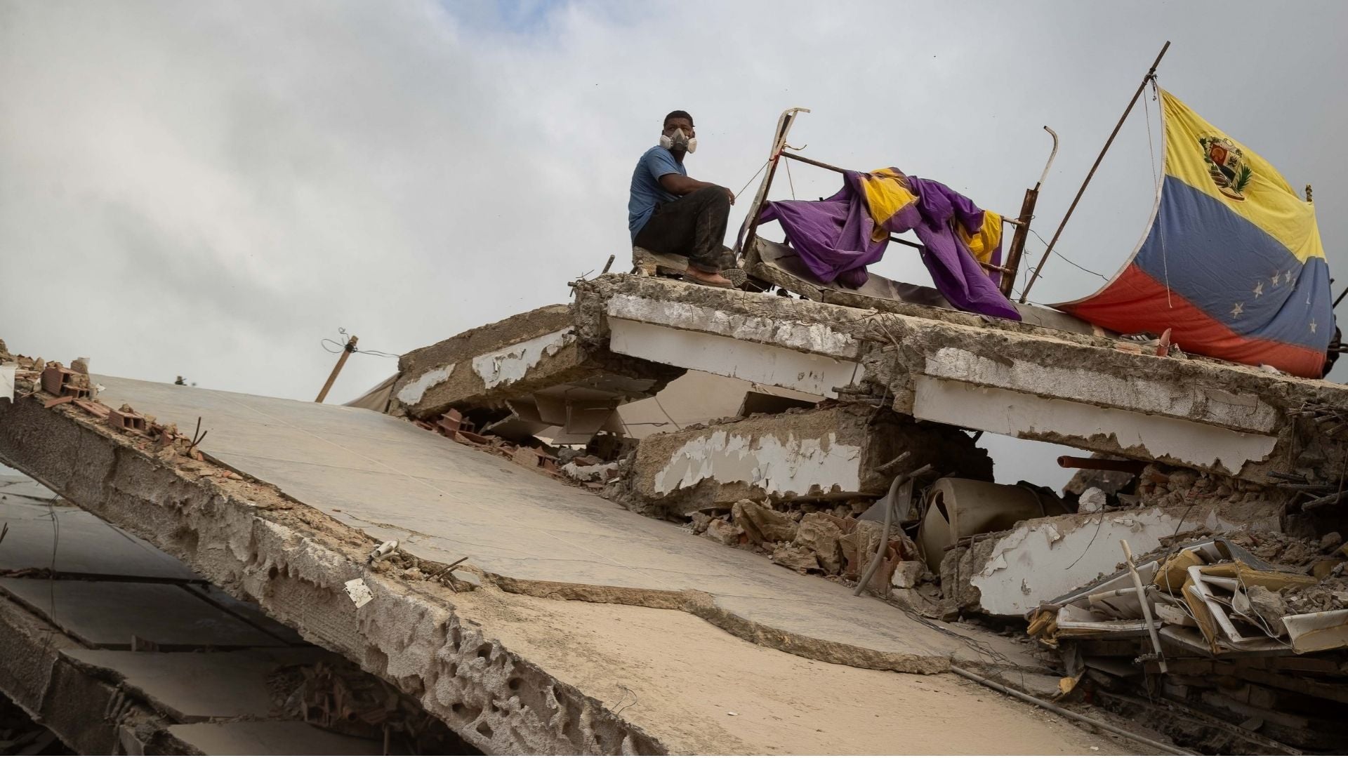 Hombre trabaja entre los escombros de edificios colapsados por los terremotos del pasado 24 de junio en La Guaira (Venezuela) - Foto de referencia: EFE