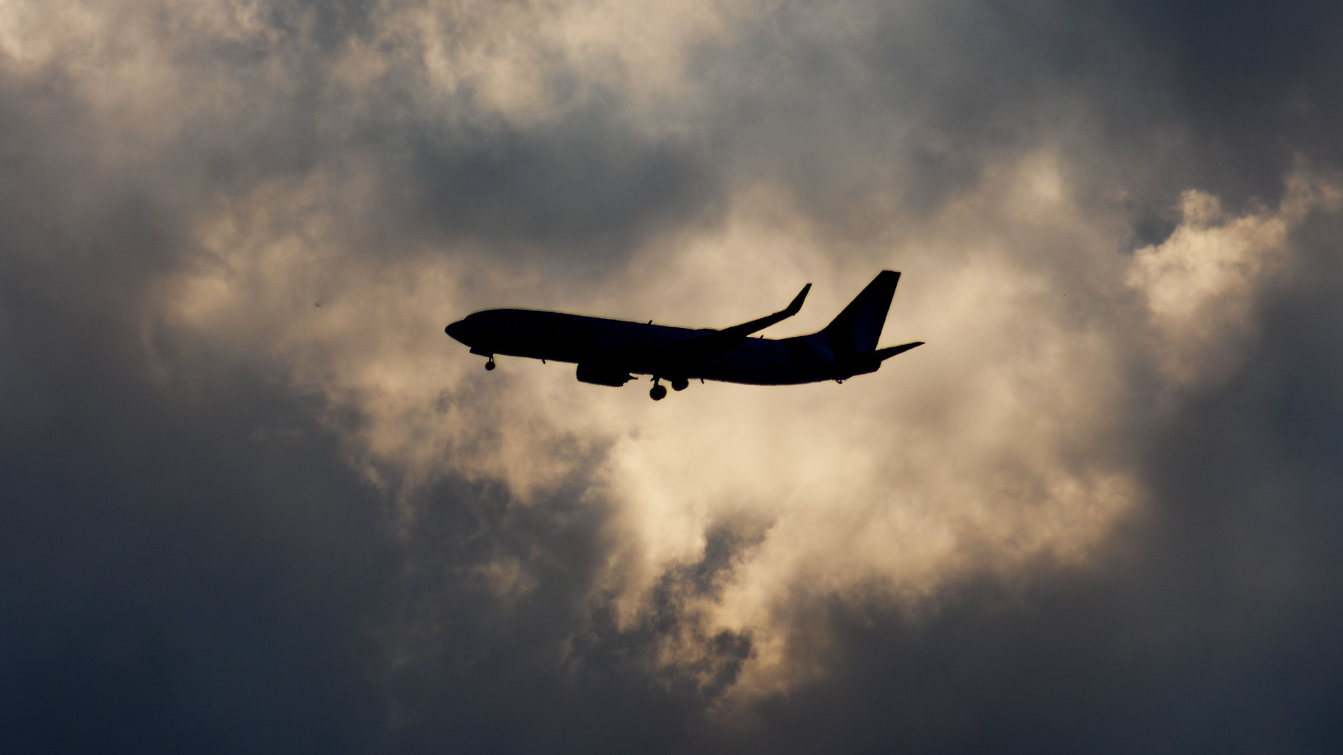 Silueta de un avión volando entre nubes - Foto de referencia: Pexels