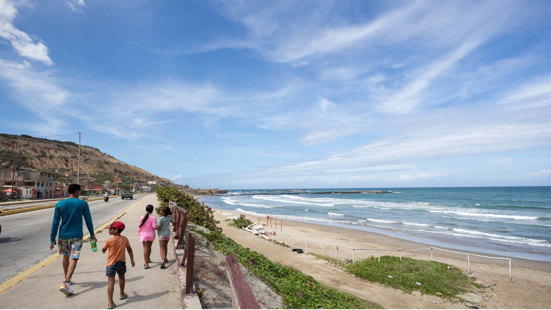Personas caminando frente a una playa en La Guaira (Venezuela) - Foto de referencia: EFE