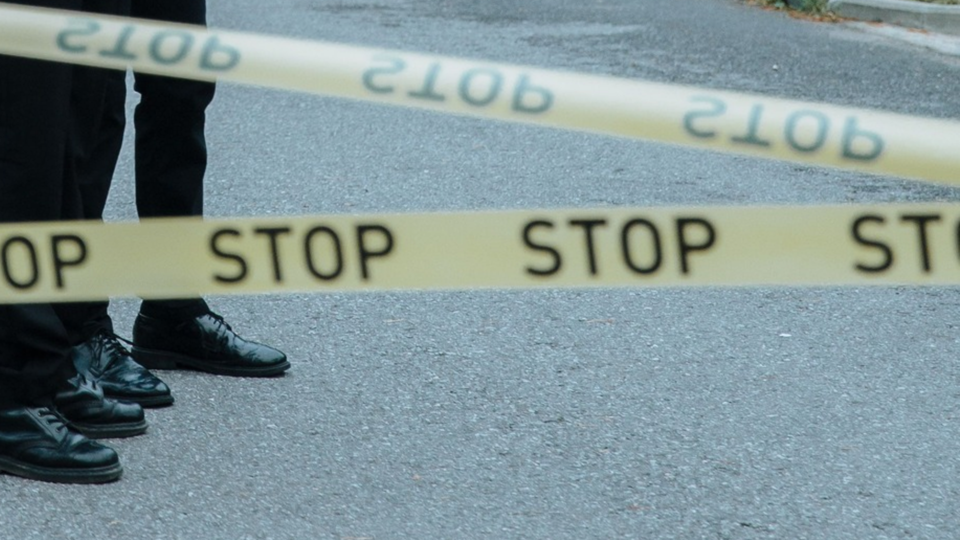 Dos oficiales de policía investigan una escena del crimen acordonada con cinta amarilla en una zona suburbana en EE. UU. - Foto de referencia: Pexels