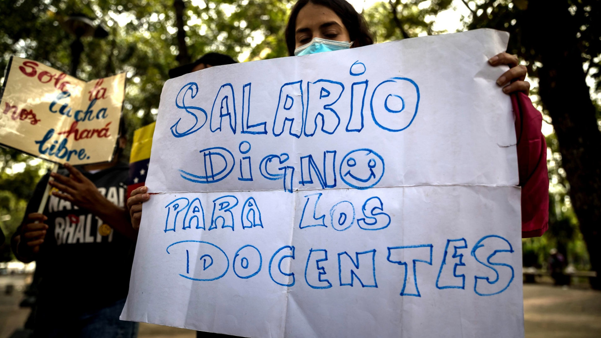 Una mujer sostiene un cartel en una manifestación de docentes en Venezuela - Foto de referencia: EFE